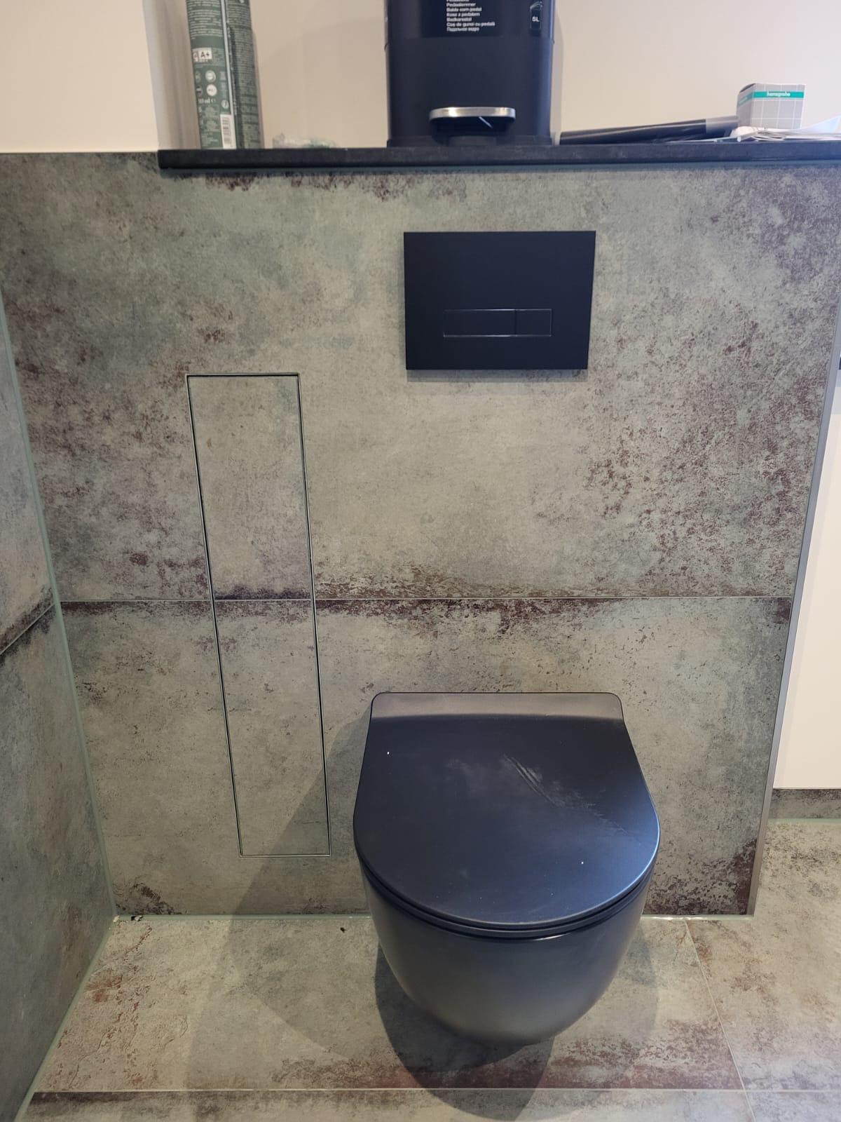 Fertiges Toilettenelement Moderne Toilettenanlage mit schwarzem WC und minimalistischer Wandverkleidung.